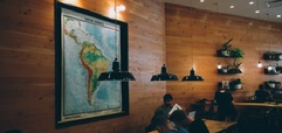 Students study in a dimly lit room, a map of South America on the wall